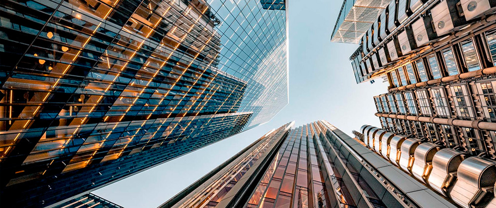 Modern city skyscrapers viewed from below representing private credit markets, infrastructure debt, real assets and institutional investment strategy.