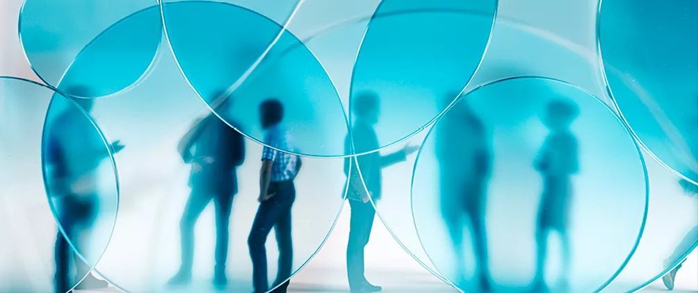 Blue-tinted abstract image of people behind circular glass shapes representing Adams Street Partners’ discussion of BDC and interval fund redemptions, transparency and private credit manager quality.