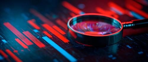 Magnifying glass over red and blue market charts representing fixed income analysis, economic data and market outlook.